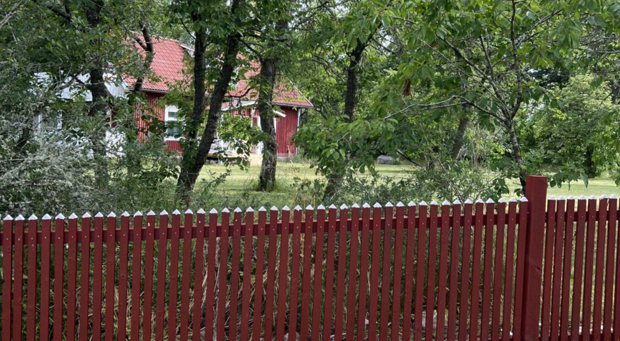 Staket byggt i bränt trä i röd färg.